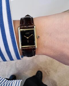 Cartier Tank with a black Dial on the wrist.
