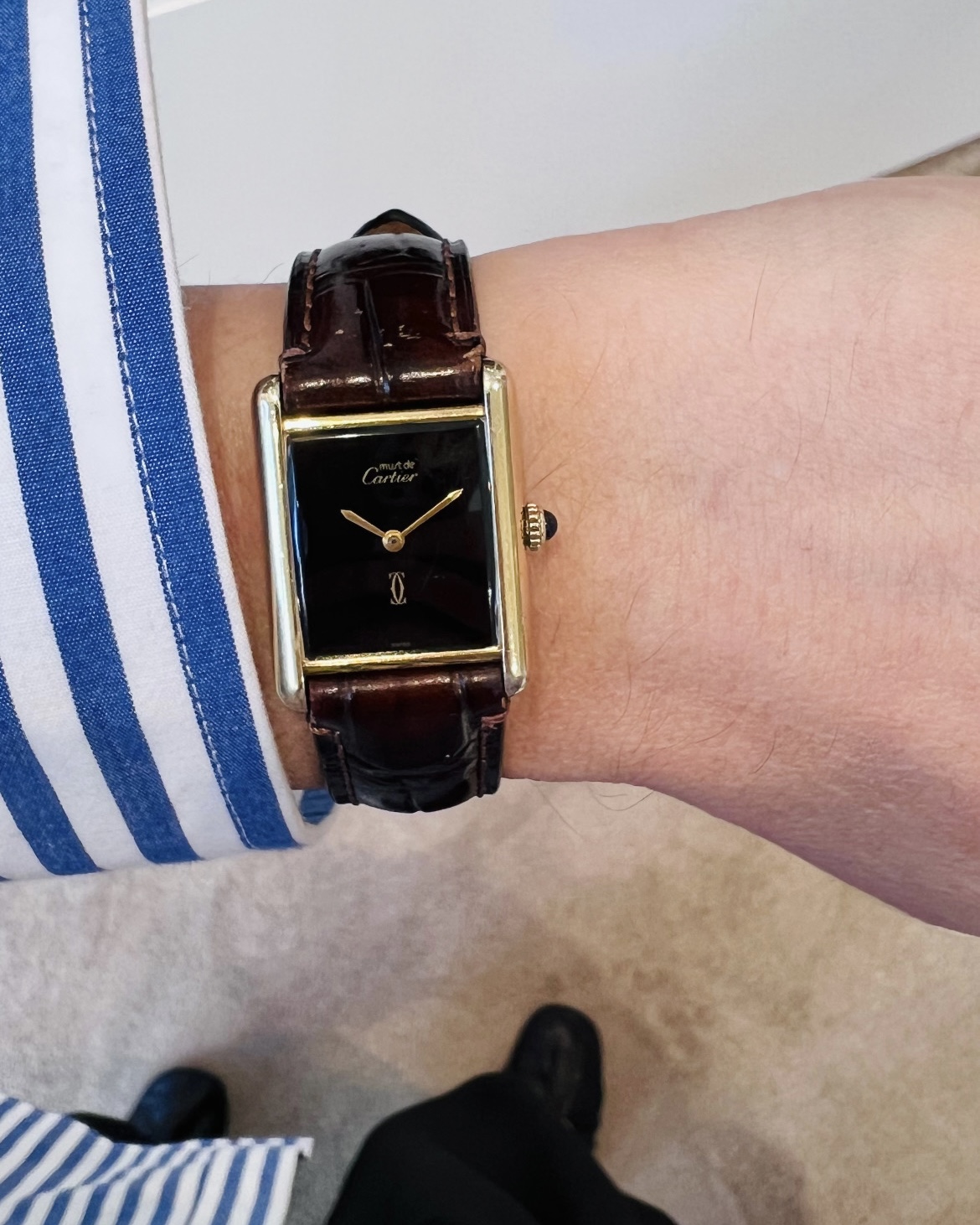 Cartier Tank with a black Dial on the wrist.
